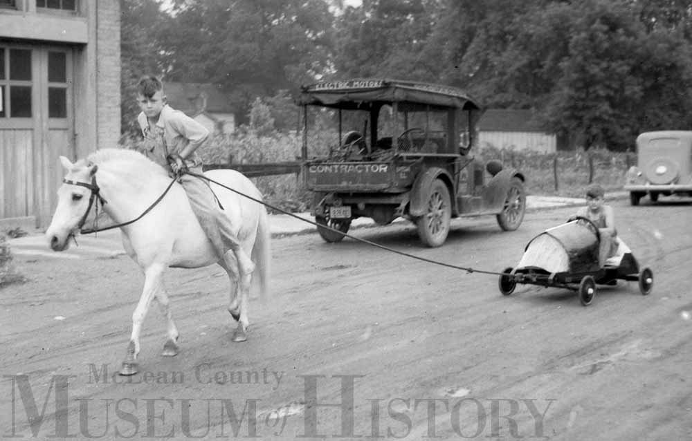 That’s Bob Butler on the white pony towing Eugene Stauffer, third-place soap box derby finisher in the Class B division.
