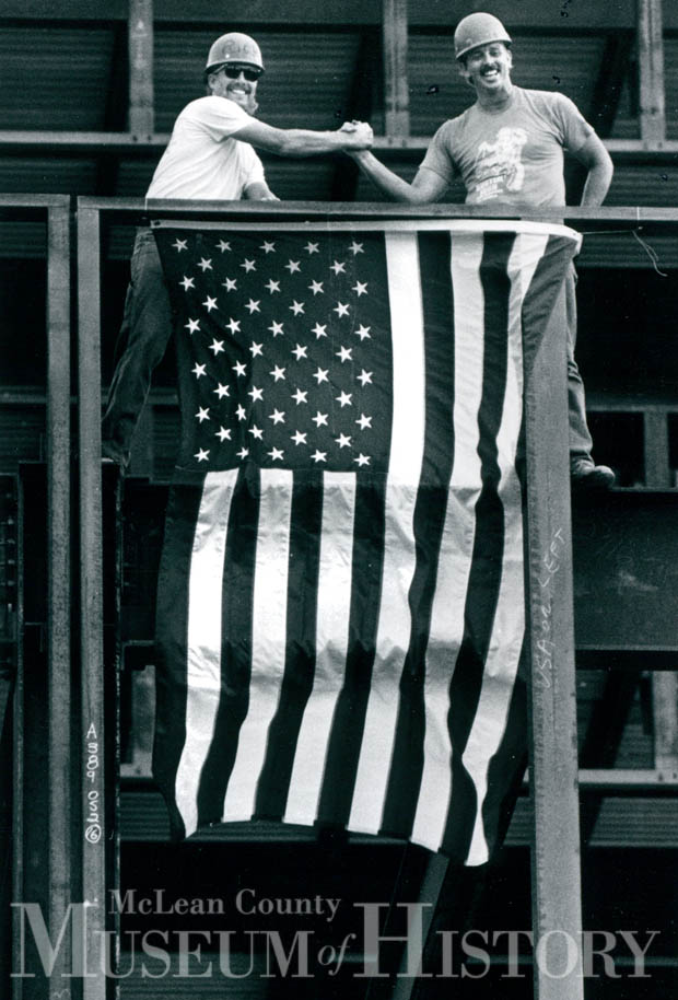 Ironworkers holding a flag, 1990.
