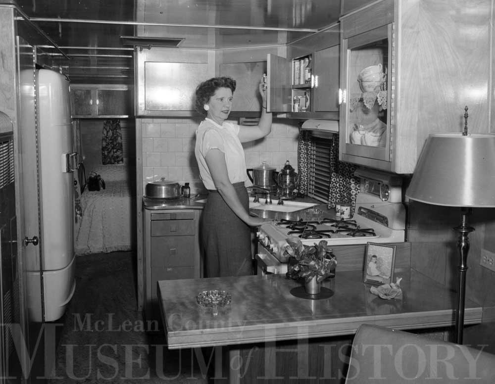 Woman standing in the kitchen of a mobile home, 1953